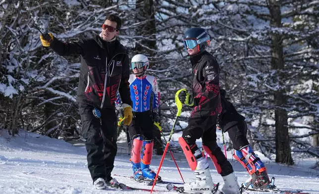 Coach Jeremie Barnier, left, supervises a training session with Melanie De Bona and Antoine Maure, in Lans-en-Vercors, near Grenoble, France, Friday, Feb. 13, 2026. (AP Photo/Laurent Cipriani)