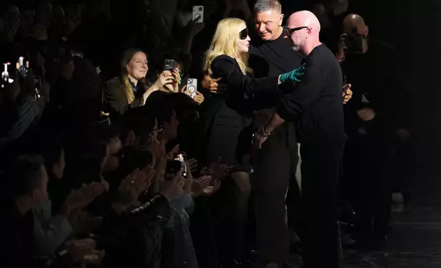 Madonna congratulates Domenico Dolce, right, and Stefano Gabbana at the end of the Dolce &amp; Gabbana Fall/Winter 2026-2027 Women's collection, presented in Milan, Italy, Saturday, Feb. 28, 2026. (AP Photo/Antonio Calanni)