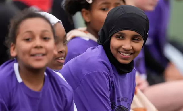 Amina Mohamed, right, sits with teammates during a soccer tournament for immigrant and refugee girls on Sunday, March 29, 2026, in Portland, Ore. (AP Photo/Jenny Kane)