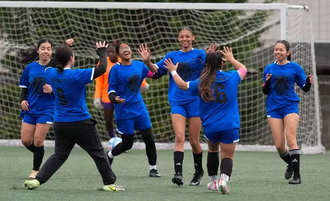 Aubrey Decraig, third from right, celebrates with teammates after scoring a goal during a soccer tournament for immigrant and refugee girls on Sunday, March 29, 2026, in Portland, Ore. (AP Photo/Jenny Kane)