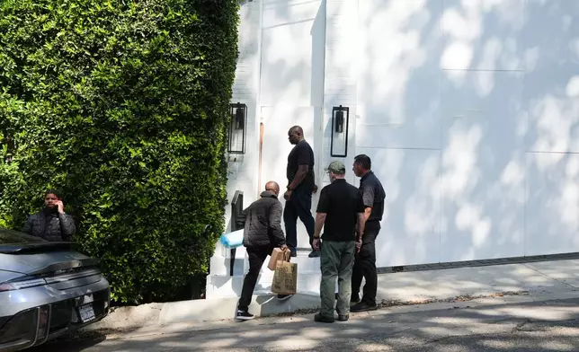 A group enters Rihanna's property Monday, March 9, 2026, in Beverly Hills, Calif. (AP Photo/Damian Dovarganes)