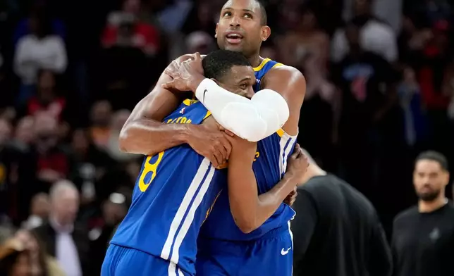 Golden State Warriors guard De'anthony Melton, left, hugs Al Horford after making a basket against the Houston Rockets during overtime of an NBA basketball game, Thursday, March 5, 2026, in Houston. (AP Photo/Eric Christian Smith)