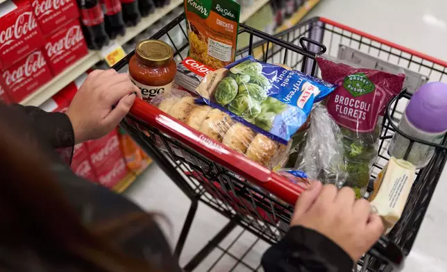FILE - A California's SNAP benefits shopper pushes a cart through a supermarket in Bellflower, Calif., Feb. 13, 2023. (AP Photo/Allison Dinner, File)