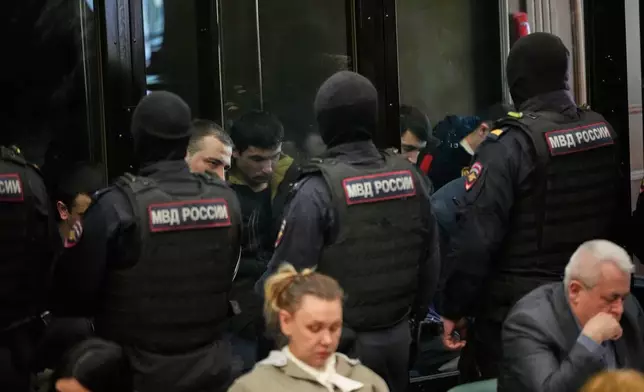 Men tried on the charges of involvement in a terror attack at the Crocus City Hall in March 2024 listen to the verdict in a glass cage at the Second Western District Military Court in Moscow, Russia, Thursday, March 12, 2026. (AP Photo/Pavel Bednyakov)