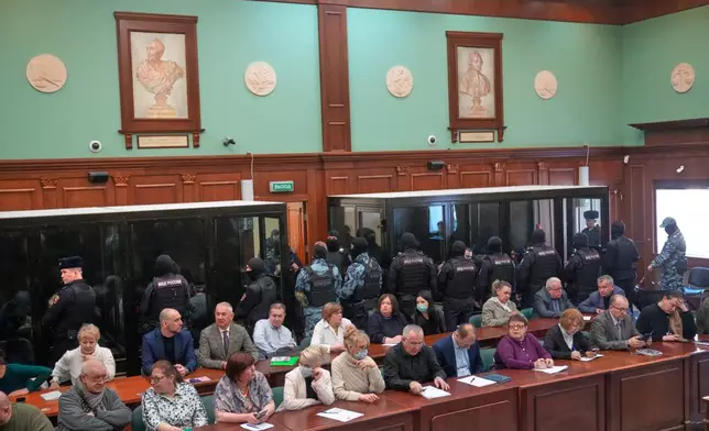 Men tried on the charges of involvement in a terror attack at the Crocus City Hall in March 2024 listen to the verdict in a glass cage at the Second Western District Military Court in Moscow, Russia, Thursday, March 12, 2026. (AP Photo/Pavel Bednyakov)