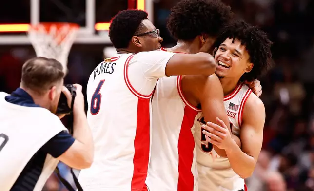 Arizona guard Bryce James (6), forward Koa Peat, center, and guard Brayden Burries celebrate after a win over Purdue in the Elite Eight of the NCAA college basketball tournament, Saturday, March 28, 2026, in San Jose, Calif. (AP Photo/Kelley L Cox)