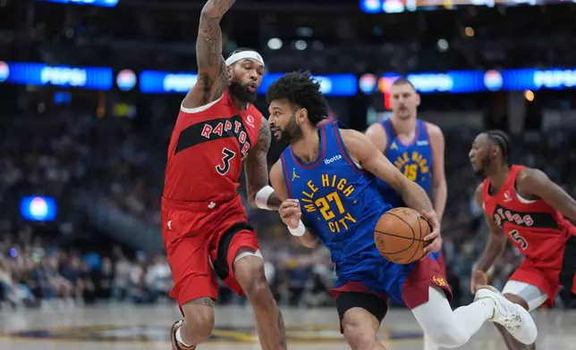 Denver Nuggets guard Jamal Murray, right, drives past Toronto Raptors forward Brandon Ingram in the first half of an NBA basketball game Friday, March 20, 2026, in Denver. (AP Photo/David Zalubowski)