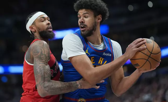 Toronto Raptors forward Brandon Ingram, left, stops Denver Nuggets forward Cameron Johnson as he tries to drive the baseline to the net in the first half of an NBA basketball game Friday, March 20, 2026, in Denver. (AP Photo/David Zalubowski)
