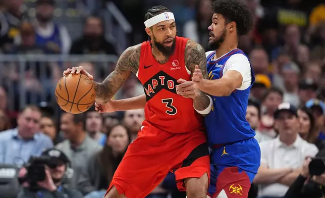 Toronto Raptors forward Brandon Ingram, left, works against Denver Nuggets forward Cameron Johnson in the first half of an NBA basketball game Friday, March 20, 2026, in Denver. (AP Photo/David Zalubowski)