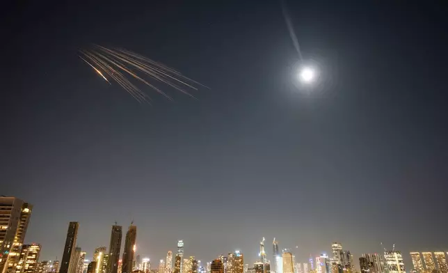 Missiles launched from Iran are seen in the sky over central Israel, Thursday, March 5, 2026. (AP Photo/Ohad Zwigenberg)