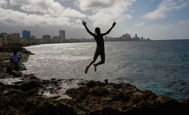 A youth jumps into the sea during a blackout in Havana, Wednesday, March 4, 2026. (AP Photo/Ramon Espinosa)