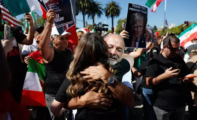 Demonstrators embrace as they march in reaction to the U.S. and Israeli strikes on Iran on Saturday, Feb. 28, 2026, in Los Angeles. (AP Photo/Caroline Brehman)