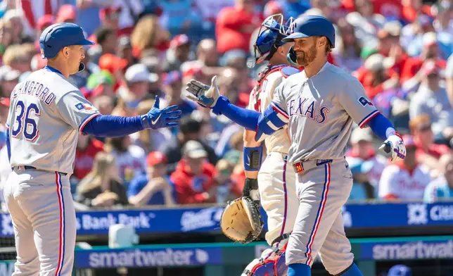 Texas Rangers' Brandon Nimmo, right, celebrates his two run homer with Wyatt Langford (36) in the third inning of a baseball game against the Philadelphia Phillies, Sunday, March 29, 2026, in Philadelphia. (AP Photo/Laurence Kesterson)