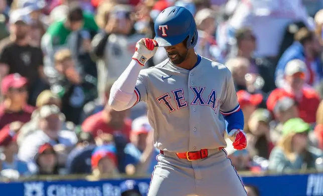 Texas Rangers' Andrew McCutchen tips his hat at home after hitting a three run home run in the fourth inning of a baseball game against the Philadelphia Phillies, Sunday, March 29, 2026, in Philadelphia. (AP Photo/Laurence Kesterson)