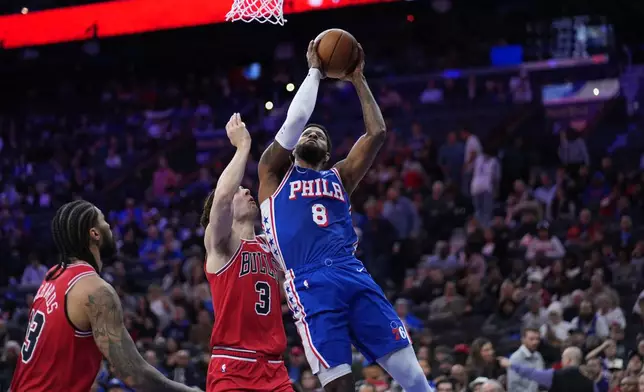 Philadelphia 76ers' Paul George, right, goes up for a shot against Chicago Bulls' Josh Giddey during the first half of an NBA basketball game Wednesday, March 25, 2026, in Philadelphia. (AP Photo/Matt Slocum)