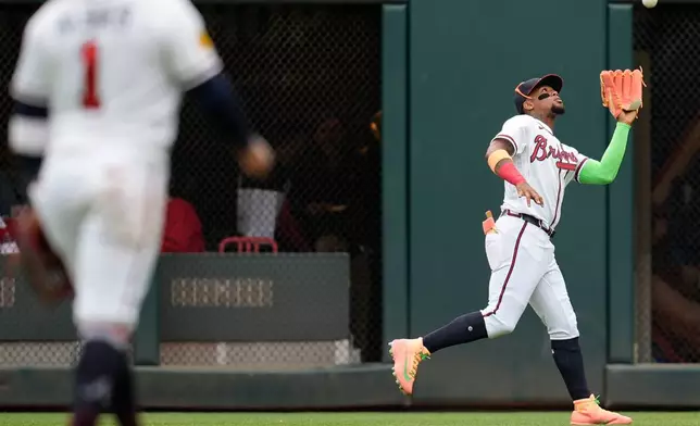Atlanta Braves right fielder Ronald Acuña Jr. (13) makes the catch against Kansas City Royals catcher Salvador Perez in the second inning of a baseball game, Sunday, March 29, 2026, in Atlanta. (AP Photo/Mike Stewart)