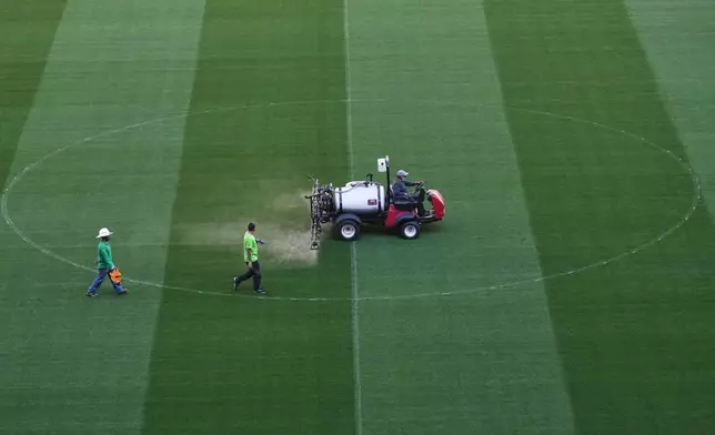 Workers traverse the pitch of the Azteca Stadium during a press tour showcasing renovations ahead of the 2026 World Cup, in Mexico City, Thursday, March 26, 2026. (AP Photo/Marco Ugarte)