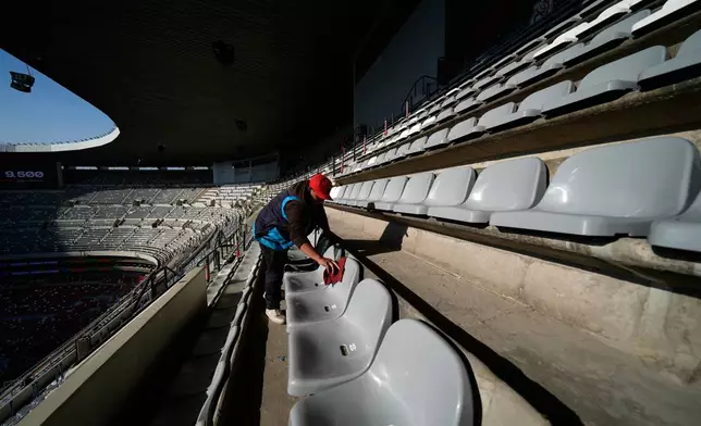 A worker cleans seats at the Azteca Stadium during a press tour showcasing renovations ahead of the 2026 World Cup, in Mexico City, Thursday, March 26, 2026. (AP Photo/Marco Ugarte)