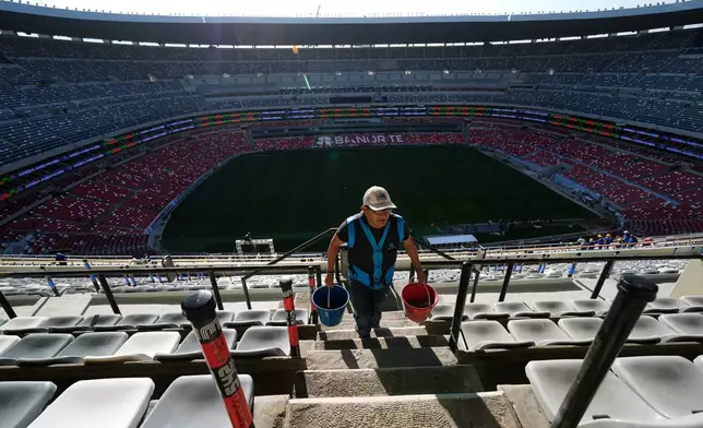 A worker carries buckets at the Azteca Stadium during a press tour showcasing renovations ahead of the 2026 World Cup, in Mexico City, Thursday, March 26, 2026. (AP Photo/Marco Ugarte)