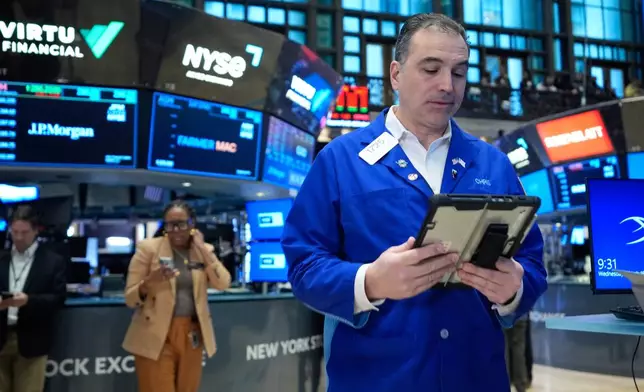 Christopher Lagana works on the floor at the New York Stock Exchange in New York, Wednesday, March 18, 2026. (AP Photo/Seth Wenig)