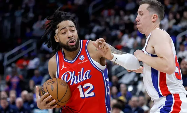 Philadelphia 76ers forward Trendon Watford (12) drives against Detroit Pistons forward Duncan Robinson during the first half of an NBA basketball game, Thursday, March 12, 2026, in Detroit. (AP Photo/Duane Burleson)