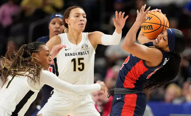 Mississippi guard Denim DeShields pulls the ball away form Vanderbilt guard Mikayla Blakes (1) and guard Ndjakalenga Mwenentanda during second half of an NCAA college basketball game in the quarterfinals of the Southeastern Conference tournament, Friday, March 6, 2026, in Greenville, S.C. (AP Photo/Chris Carlson)
