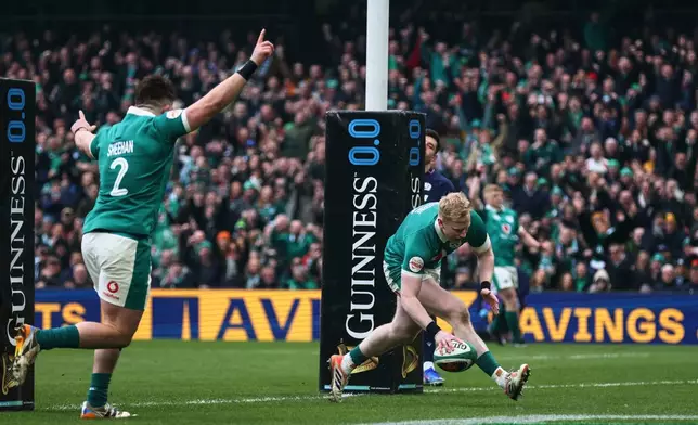 Ireland's Jamie Osborne, right, scores a try as teammate Dan Sheehan celebrates during the Six Nations rugby union match between Ireland and Scotland, in Dublin, Saturday, March 14, 2026. (AP Photo/Peter Morrison)