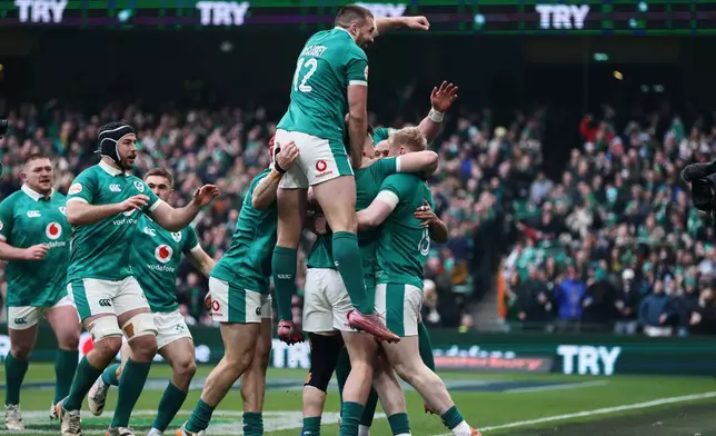 Ireland's Jamie Osborne, right, celebrates his teammates after scoring a try during the Six Nations rugby union match between Ireland and Scotland, in Dublin, Saturday, March 14, 2026. (AP Photo/Peter Morrison)