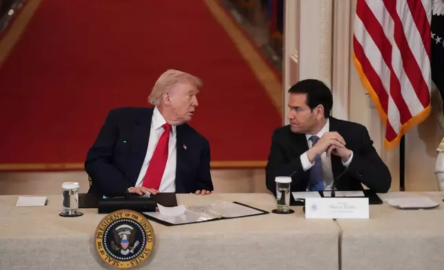 President Donald Trump speaks with Secretary of State Marco Rubio during a roundtable discussion on college sports in the East Room of the White House, Friday, March 6, 2026, in Washington. (AP Photo/Julia Demaree Nikhinson)