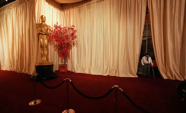 A security guard stands along an empty red carpet Saturday, March 14, 2026, at the Dolby Theatre in Los Angeles, the night before Sunday's 98th Academy Awards ceremony. (AP Photo/Gregory Bull)