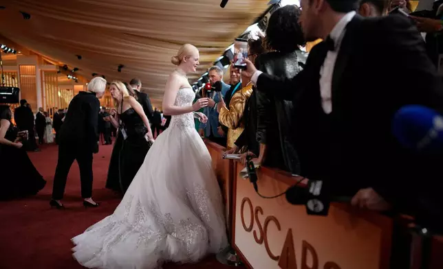 Elle Fanning, left, seen with Guillermo Rodriguez as she arrives at the Oscars on Sunday, March 15, 2026, at the Dolby Theatre in Los Angeles. (AP Photo/John Locher)