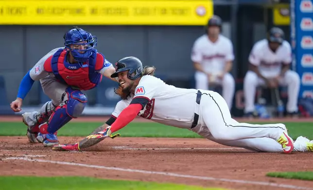 Cleveland Guardians shortstop Gabriel Arias, right, is tagged out at home by Chicago Cubs catcher Carson Kelly, left, in the fifth inning of a baseball game in Cleveland, Friday, April 3, 2026. (AP Photo/Sue Ogrocki)