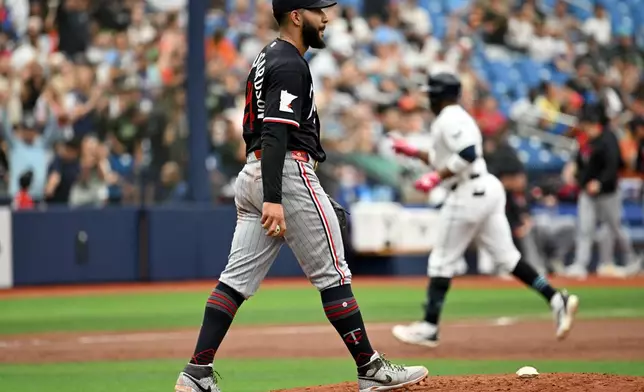Minnesota Twins pitcher Simeon Woods Richardson walks back to the mound as Tampa Bay Rays' Yandy Díaz rounds the bases after his two-run home run during the third inning of a baseball game Sunday, April 26, 2026, in St. Petersburg, Fla. (AP Photo/Jason Behnken)
