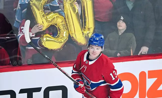 Montreal Canadiens' Cole Caufield (13) skates by the number 50 prior to an NHL hockey game against the New Jersey Devils, in Montreal, Sunday, April 5, 2026. Caufield is one goal away from scoring his 50th for the regular season. (Graham Hughes/The Canadian Press via AP)