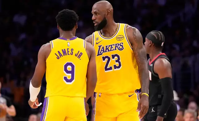 Los Angeles Lakers forward LeBron James, right, talks to his son guard Bronny James during the first half in Game 1 of a first-round NBA playoffs basketball series against the Houston Rockets, Saturday, April 18, 2026, in Los Angeles. (AP Photo/Mark J. Terrill)