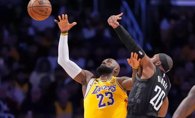 Los Angeles Lakers forward LeBron James, left, takes a pass as Houston Rockets guard Josh Okogie defends during the first half in Game 1 of a first-round NBA playoffs basketball series Saturday, April 18, 2026, in Los Angeles. (AP Photo/Mark J. Terrill)