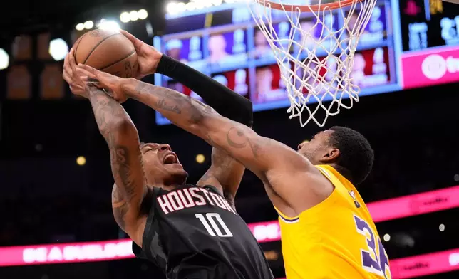 Houston Rockets forward Jabari Smith Jr., left, shoots as Los Angeles Lakers guard Marcus Smart defends during the first half in Game 1 of a first-round NBA playoffs basketball series Saturday, April 18, 2026, in Los Angeles. (AP Photo/Mark J. Terrill)