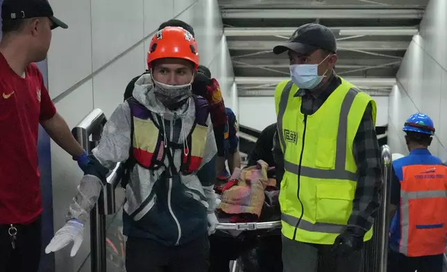Rescuers carry a victim of a train collision in Bekasi, Indonesia, Monday, April 27, 2026. (AP Photo/Achmad Ibrahim)