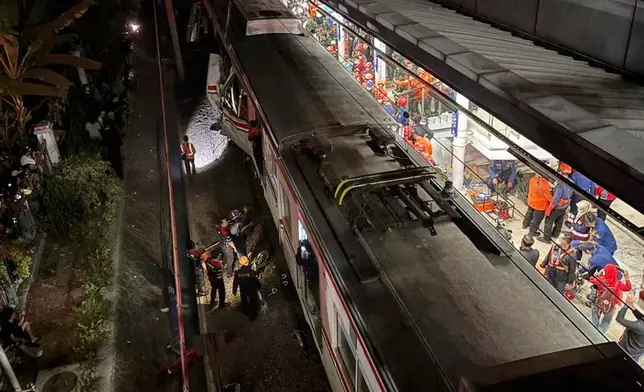 Rescuers search for victims after a train collision at a station in Bekasi, Indonesia, Monday, April 27, 2026. (AP Photo/Achmad Ibrahim)