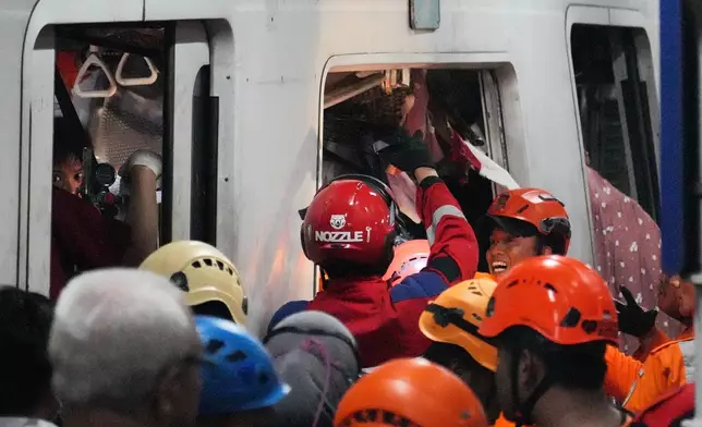 Rescuers search for victims after a train collision at a station in Bekasi, Indonesia, Monday, April 27, 2026. (AP Photo/Achmad Ibrahim)