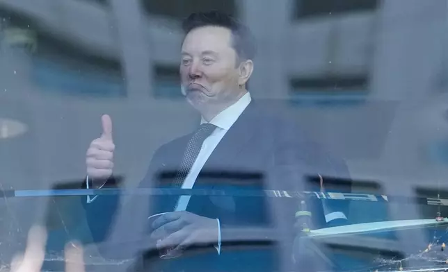 Elon Musk, left, gestures as he walks through a hallway inside the U.S. District Court in Oakland, Calif., Wednesday, April 29, 2026. (AP Photo/Godofredo A. Vásquez)