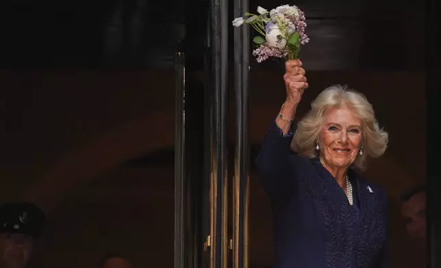 Queen Camilla waves flowers outside the New York Public Library, Wednesday, April 29, 2026, in New York. (AP Photo/Ryan Murphy)