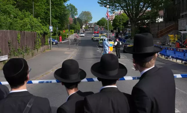 Members of the community watch as forensic officers search the area after two people were stabbed in the Golders Green neighbourhood, that has a large Jewish community, in London, Wednesday, April 29, 2026.(AP Photo/Kin Cheung)