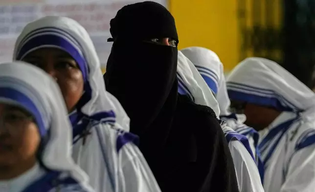 A woman in burqa stands in a queue with the nuns of the Missionaries of Charity to cast a vote in a polling station during the second phase of elections, in West Bengal state, in Kolkata, India, Wednesday, April 29, 2026. (AP Photo/Bikas Das)