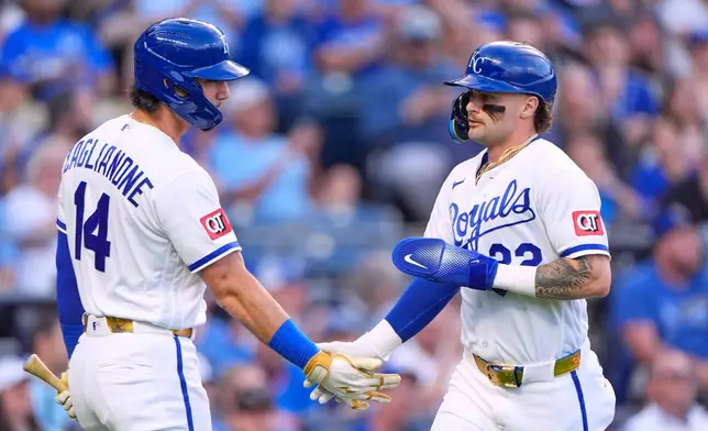 Kansas City Royals' Carter Jensen, right, celebrates with Jac Caglianone (14) after scoring on a sacrifice fly hit by Michael Massey during the second inning of a baseball game against the Baltimore Orioles, Tuesday, April 21, 2026, in Kansas City, Mo. (AP Photo/Charlie Riedel)