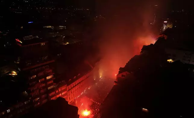 An aerial view shows smoke rising above Sarajevo as soccer fans light flares to welcome the Bosnian national team after qualifying for the World Cup by winning a penalty shootout against Italy, in Sarajevo, Bosnia, Wednesday, April 1, 2026. (AP Photo/Armin Durgut)