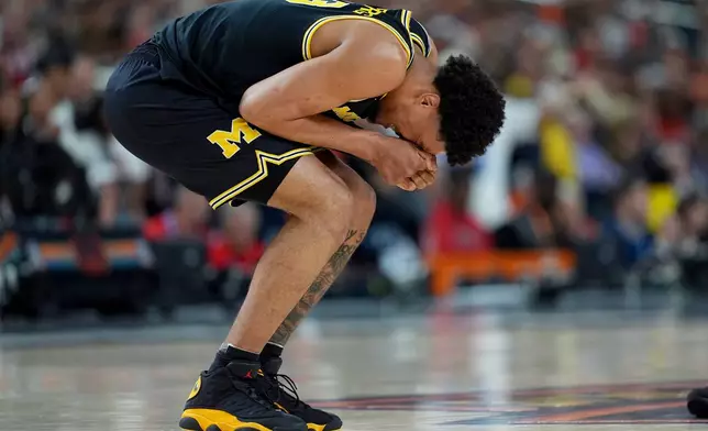 Michigan forward Yaxel Lendeborg reacts after an injury on the court during the first half of an NCAA college basketball tournament semifinal game against Arizona at the Final Four, Saturday, April 4, 2026, in Indianapolis. (AP Photo/Abbie Parr)