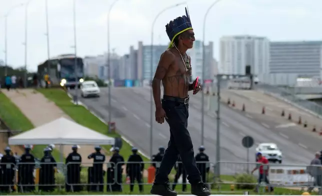 A Tupinamba Indigenous man arrives to Brazil's Supreme Court to attend a session, where justices discuss a case about reducing the size of Jamanxim National Park, in Brasilia, Wednesday, April 8, 2026. (AP Photo/Eraldo Peres)