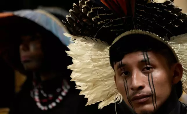 An Indigenous man eyes the camera while attending a Supreme Court session, where justices discuss a case about reducing the size of Jamanxim National Park, in Brasilia, Brazil, Wednesday, April 8, 2026. (AP Photo/Eraldo Peres)