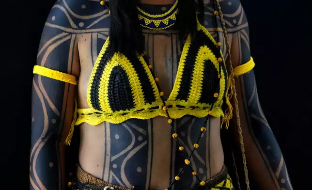 An Indigenous woman wearing traditional body paint and handcrafted clothing poses for a portrait during the opening of the "Acampamento Terra Livre," or Free Land Encampment, Brazil's largest annual Indigenous mobilization that focuses on land rights and environmental protection, in Brasilia, Brazil, Monday, April 6, 2026. (AP Photo/Eraldo Peres)